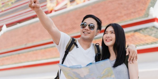 Traveler Asian couple direction on location map in Bangkok, Thailand, sweet Asia couple looking on map find landmark while spending holiday trip. Lifestyle couple travel in city concept.